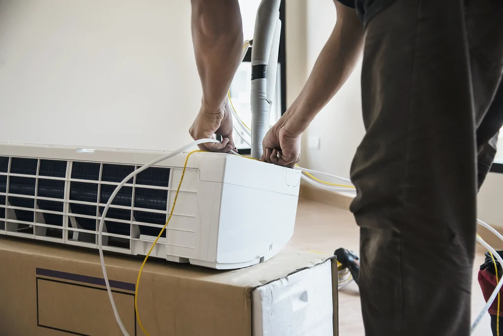 man is installing air conditioner in housing unit during hot season in thailand free photo